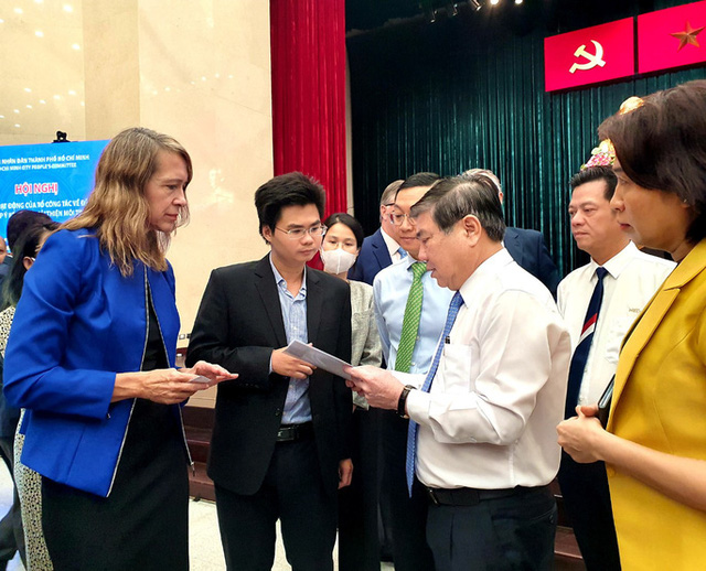 Chủ tịch UBND TP HCM Nguyễn Thành Phong (thứ 3 từ phải qua) trao đổi với doanh nghiệp nước ngoài bên lề hội nghị.